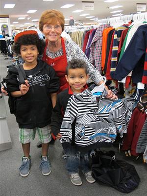 Volunteer helps children shop for clothes 
